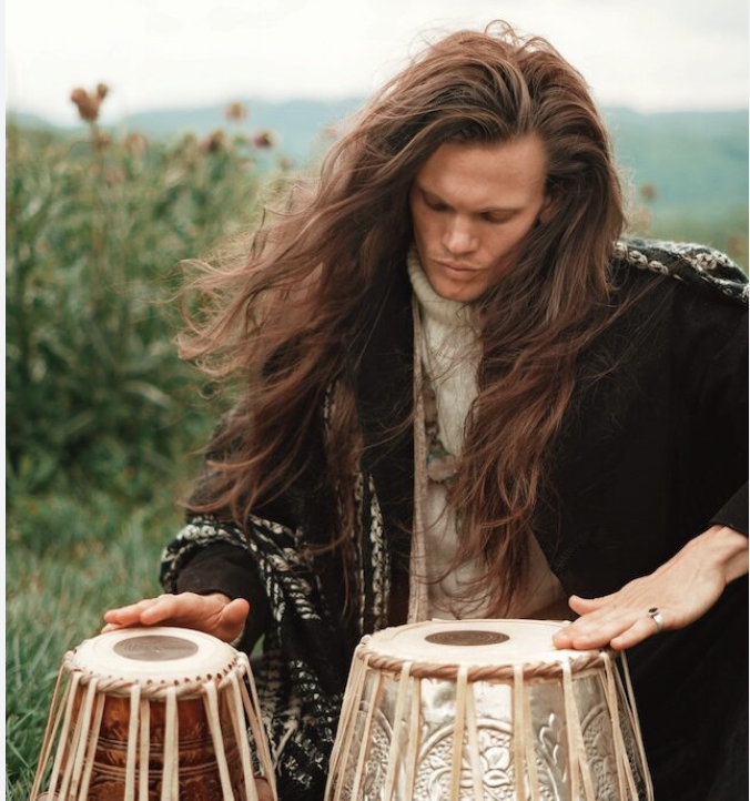 St. Finnikin playing tabla drums in nature